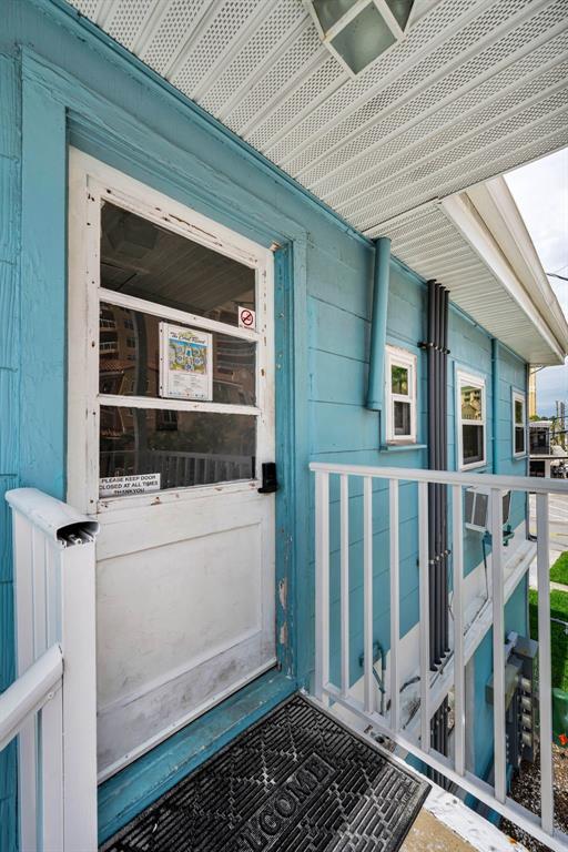 The exterior of a blue two-story apartment building features an outdoor staircase and parking spaces — 483 E SHORE DRIVE UNIT A4, CLEARWATER BEACH, FL