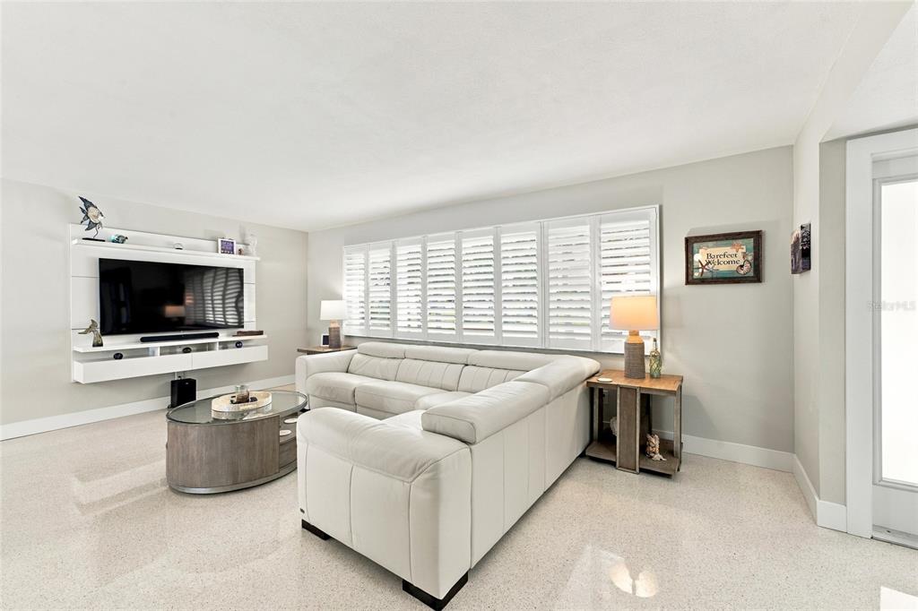 A single-story house with a gray tile roof, dark garage door, and palm trees — 4523 CLEARWATER HARBOR DRIVE S, LARGO, FL
