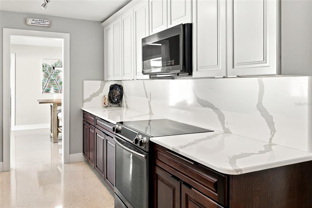 A single-story house with a white exterior, gray garage door, and a paved driveway — 4523 CLEARWATER HARBOR DRIVE S, LARGO, FL