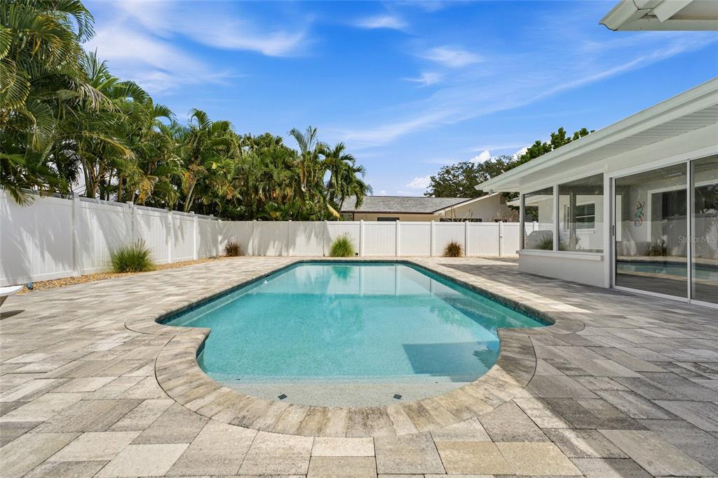 A living room and dining area with white tile floors, a sectional sofa, and cabinetry — 4523 CLEARWATER HARBOR DRIVE S, LARGO, FL