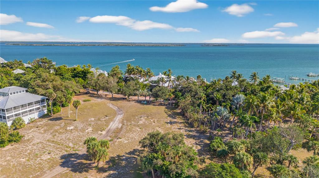 An aerial view shows a vacant lot with trees and vegetation near a coastal waterfront — 326 USEPPA ISLAND, CAPTIVA, FL