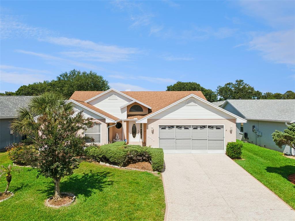 A single-story house with a tan exterior, a two-car garage, and a front lawn — 6232 EGRET DRIVE, LAKELAND, FL