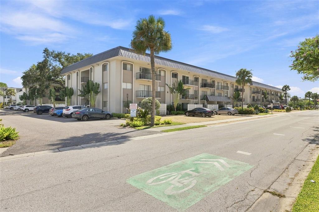 A multi-story apartment building with balconies and a parking lot sits beside a bike lane — 4606 W GRAY STREET UNIT 301, TAMPA, FL