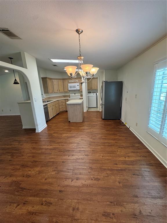 A view of an open-concept living area with wood-look flooring and a kitchen breakfast bar — 585 OUTER DRIVE, COCOA, FL