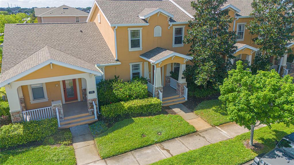 An aerial view of a two-story tan townhouse with a front porch and green lawn — 4908 TERRAPIN BOULEVARD, ST CLOUD, FL