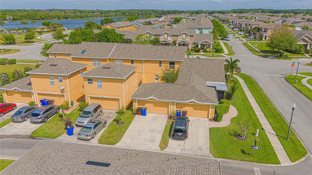 An aerial view shows a multi-unit residential building with yellow stucco walls and shingled roofs — 4908 TERRAPIN BOULEVARD, ST CLOUD, FL