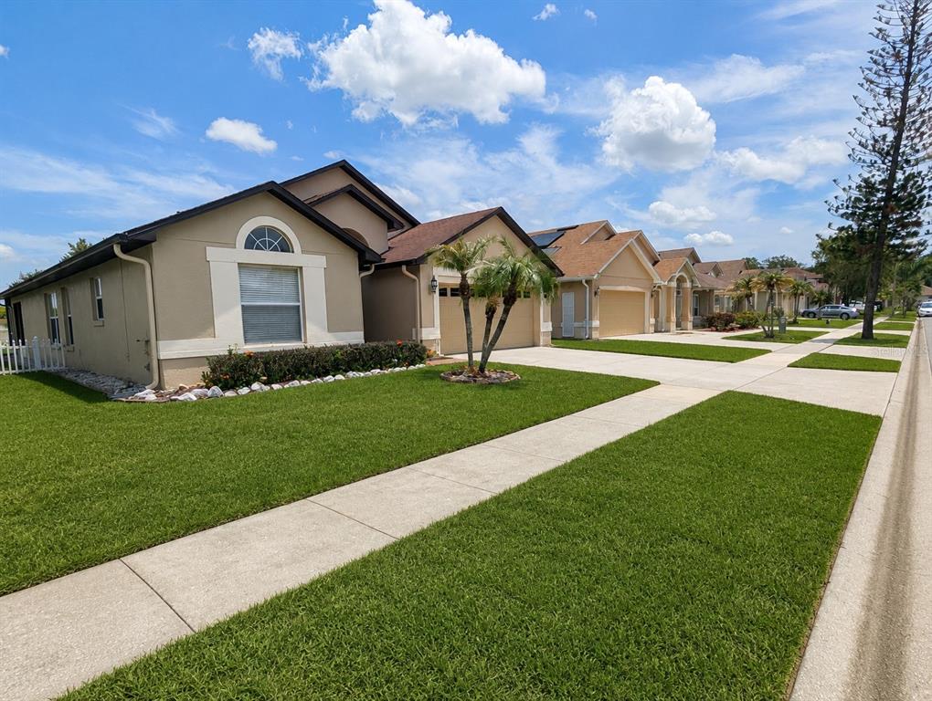 A brick entrance sign for a community named Woodstone sits in front of green landscaping — 7935 OAKSTONE COURT, ORLANDO, FL