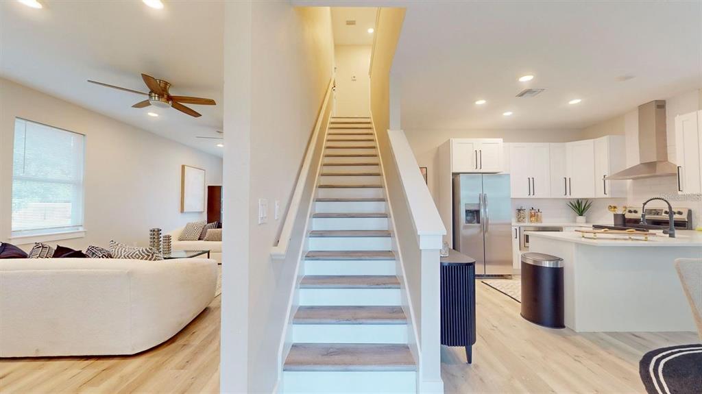 A white two-story house with a covered walkway connecting to a side porch and yard — 6910 DARTMOUTH AVENUE N, ST PETERSBURG, FL