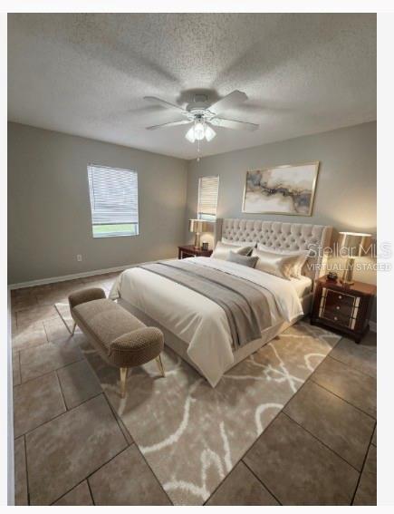 A bedroom with tile flooring, a tufted headboard, a ceiling fan, and a neutral rug — 2942 GREYNOLDS STREET, DELTONA, FL