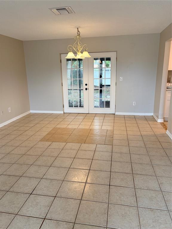 A single-story house with beige siding, brown shutters, and a front porch with landscaping — 2942 GREYNOLDS STREET, DELTONA, FL