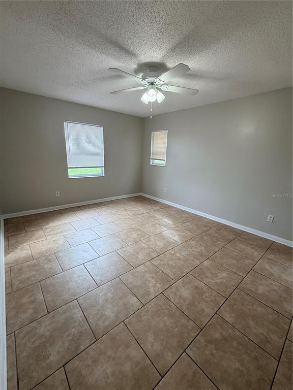 A living room with a marble coffee table, a white sofa, and an adjacent dining area — 2942 GREYNOLDS STREET, DELTONA, FL