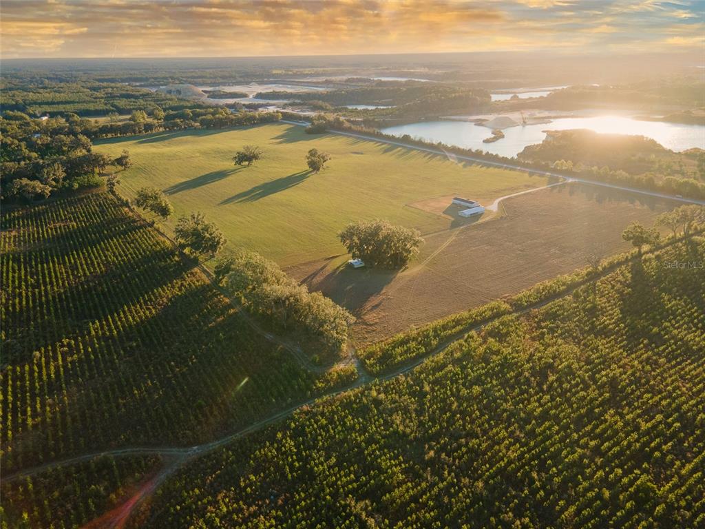 An aerial view shows a rural property with a house, pasture, and nearby lake — 3789 NW 202ND STREET, NEWBERRY, FL