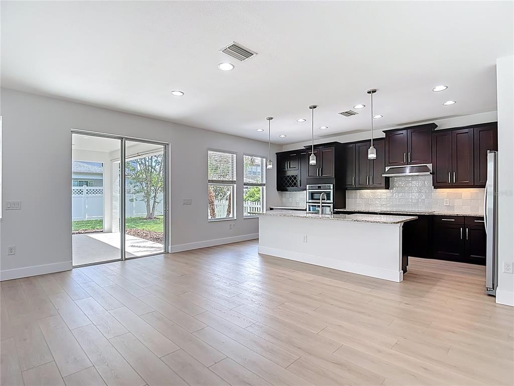 An aerial view shows two suburban houses with driveways, lawns, and palm trees — 27387 CAYENNE LANE, WESLEY CHAPEL, FL