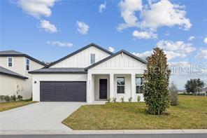 A white single-story house with a dark garage door and a front-facing gable roof — 19 BONNIE LANE, PALM COAST, FL