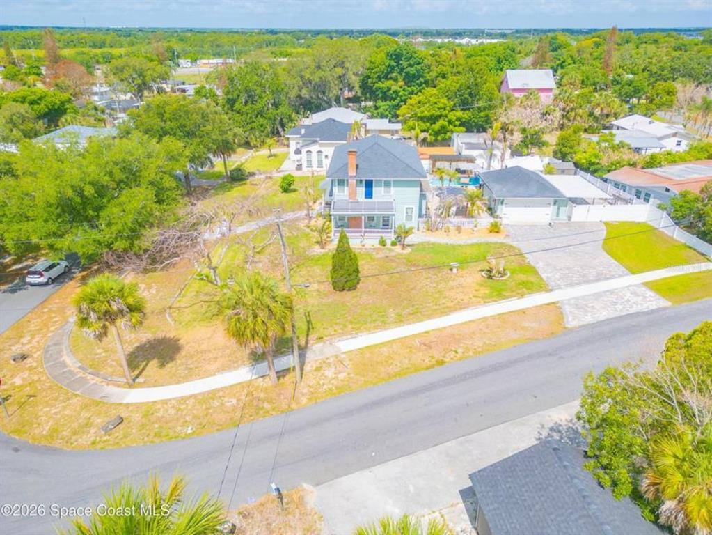 An aerial view shows a light-colored two-story house with a large yard and driveway — 308 BELLAIR DRIVE, COCOA, FL