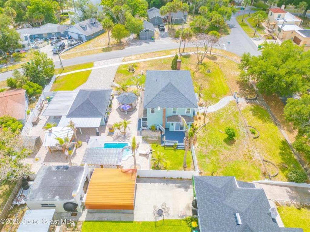 An aerial view shows a house with a pool, patio, and detached structures — 308 BELLAIR DRIVE, COCOA, FL