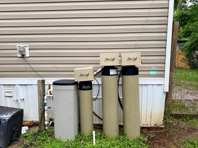 An exterior view shows a RainSoft water treatment system installed against the side of a house — 9825 LEGUNA STREET, NEW PORT RICHEY, FL