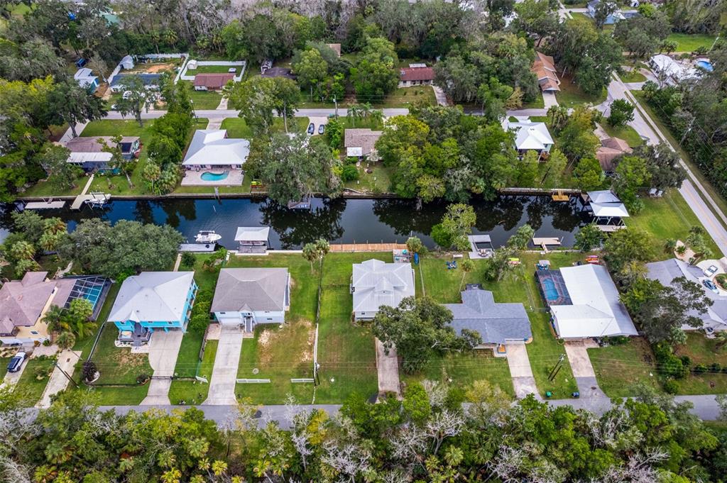 An aerial view shows waterfront houses with docks along a canal in a wooded neighborhood — 3625 N SUWANNEE POINT, CRYSTAL RIVER, FL