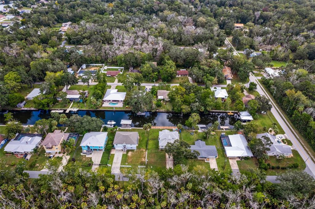 An aerial view shows houses along a canal surrounded by dense trees and vegetation — 3625 N SUWANNEE POINT, CRYSTAL RIVER, FL