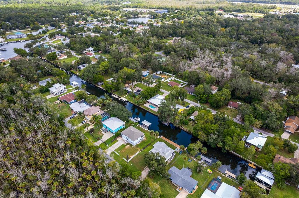 An aerial view shows houses along a canal surrounded by dense trees and vegetation — 3625 N SUWANNEE POINT, CRYSTAL RIVER, FL