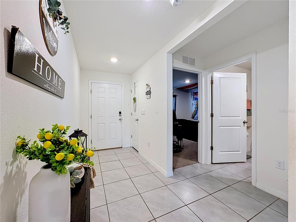 A tiled entryway features a front door, two interior doors, and a decorative wall sign — 16661 WINDMILL FORGE PASS, WIMAUMA, FL