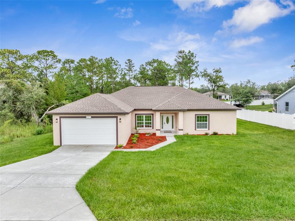 An aerial view of a single-story house with a concrete driveway and a fenced backyard — 11277 FOOL DUCK AVENUE, WEEKI WACHEE, FL