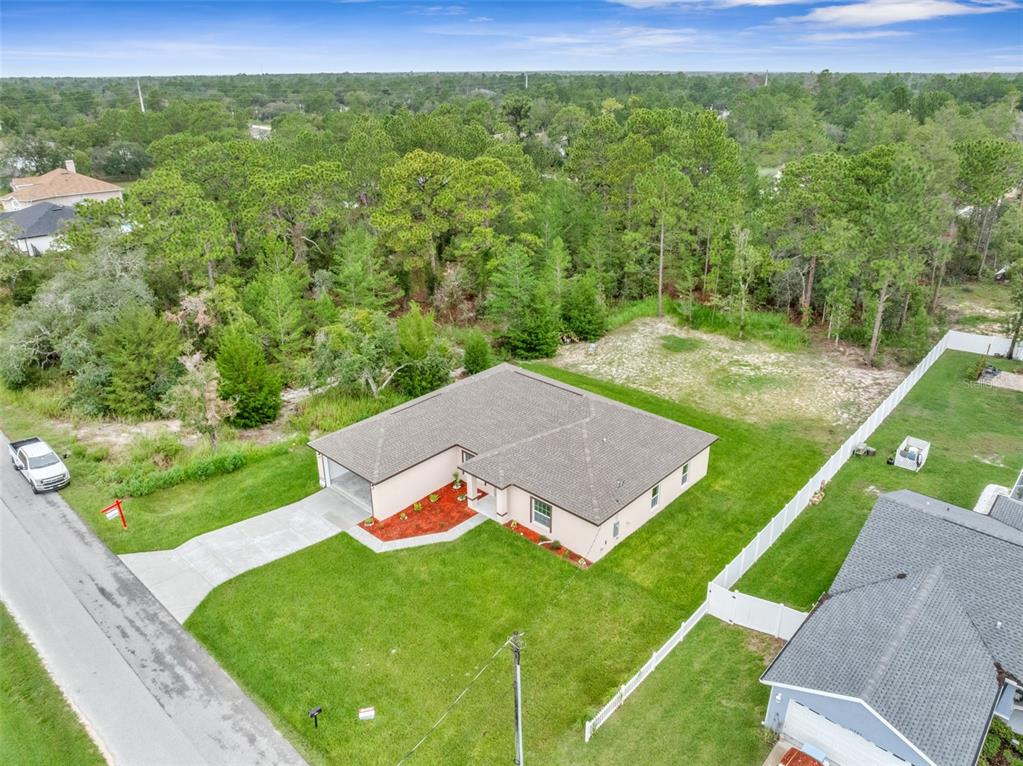 A single-story house with a beige exterior, a two-car garage, and a front lawn — 11277 FOOL DUCK AVENUE, WEEKI WACHEE, FL