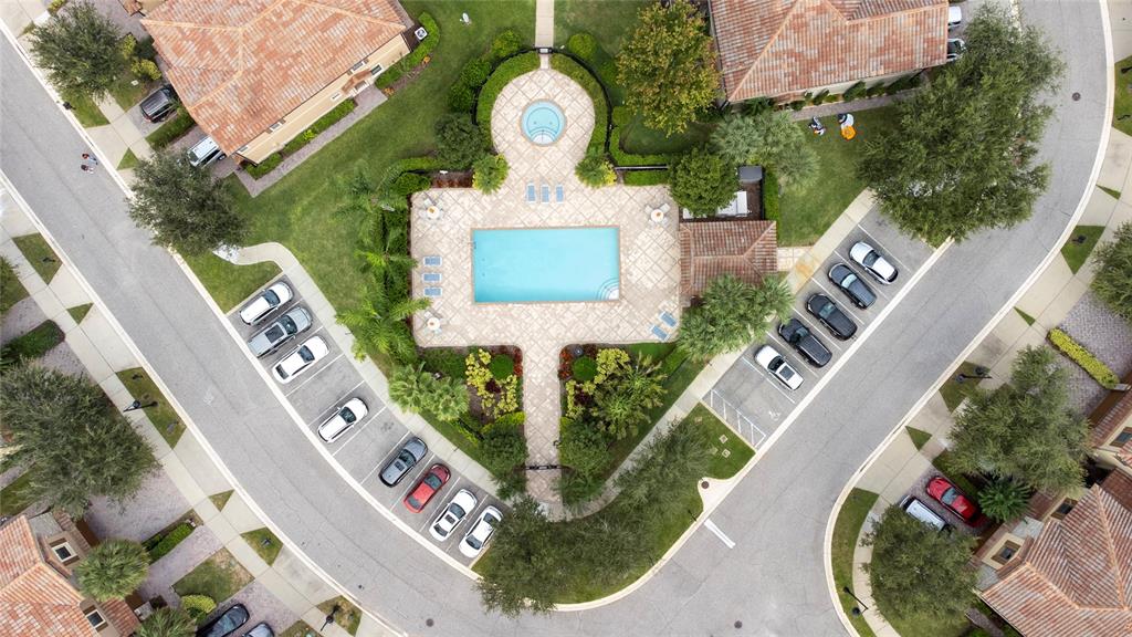 An aerial view shows a community swimming pool and spa surrounded by parking and landscaping — 8349 KELSALL DRIVE, ORLANDO, FL