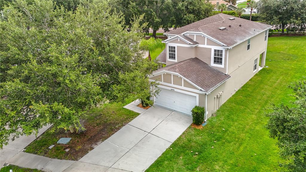 An aerial view of a two-story suburban house with a tan exterior and attached garage — 25956 TERRAWOOD LOOP, LAND O LAKES, FL