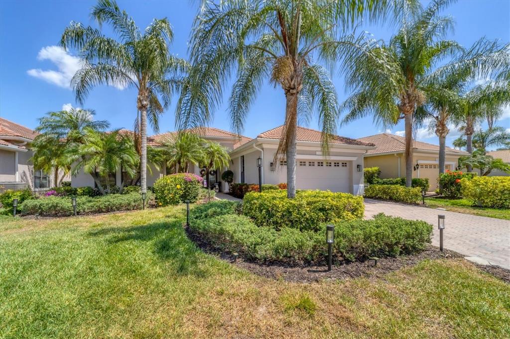 A single-story house with a tiled roof, palm trees, and a paved driveway — 13853 SIENA LOOP, LAKEWOOD RANCH, FL