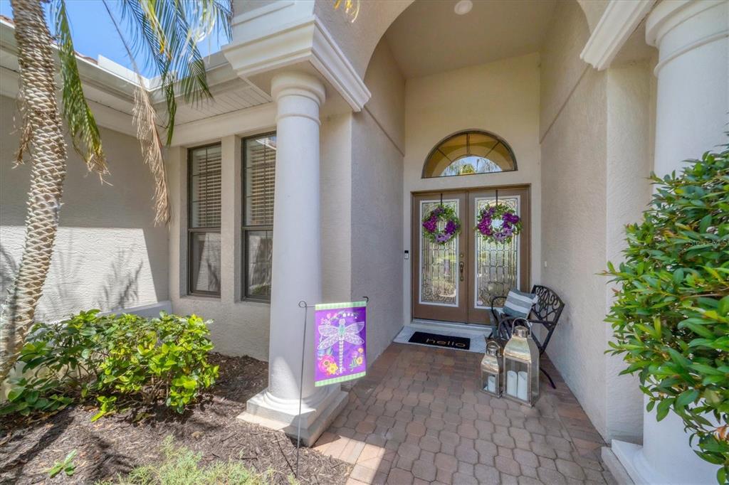 A front entryway features double glass doors, a brick walkway, and two white columns — 13853 SIENA LOOP, LAKEWOOD RANCH, FL