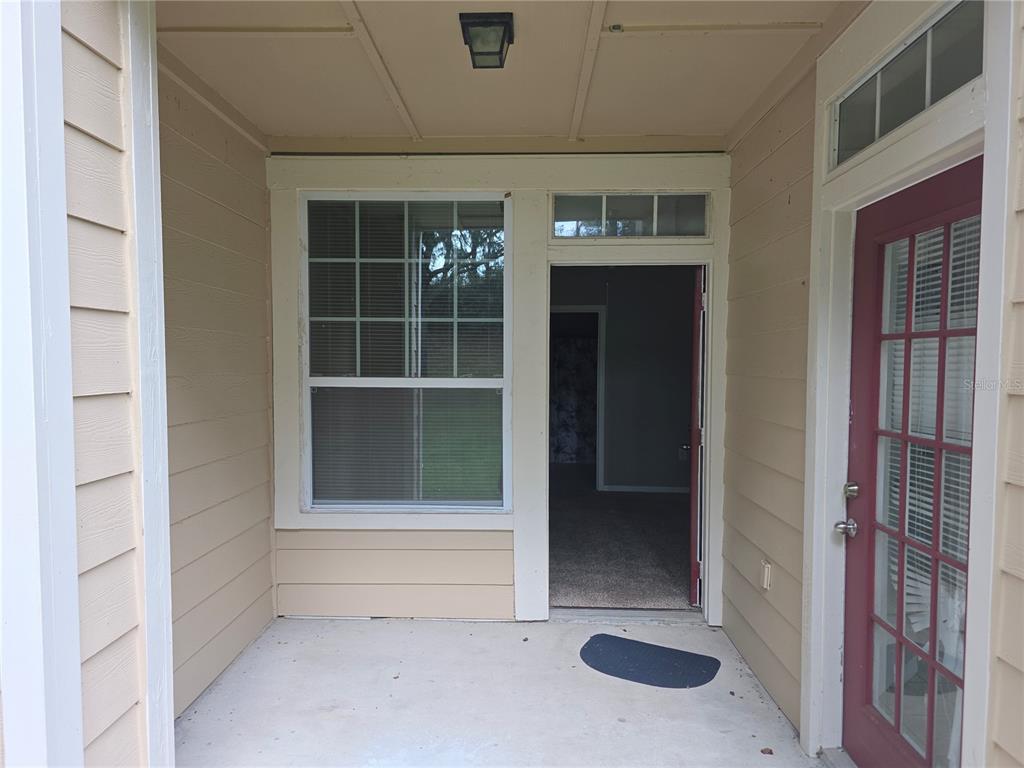 A red front door with a house number sign sits at the entrance of a home — 1101 VINTAGE VILLAGE LANE UNIT 110, OCOEE, FL