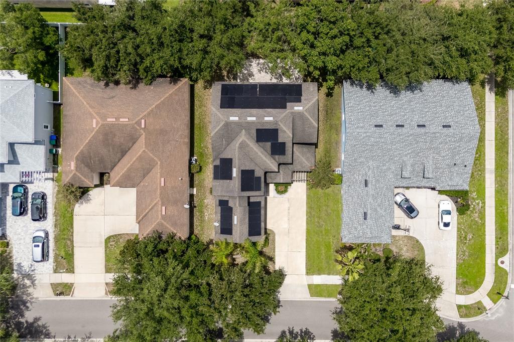 An aerial view shows three suburban houses with driveways and trees along a residential street — 4642 RIVER GEM AVENUE, WINDERMERE, FL
