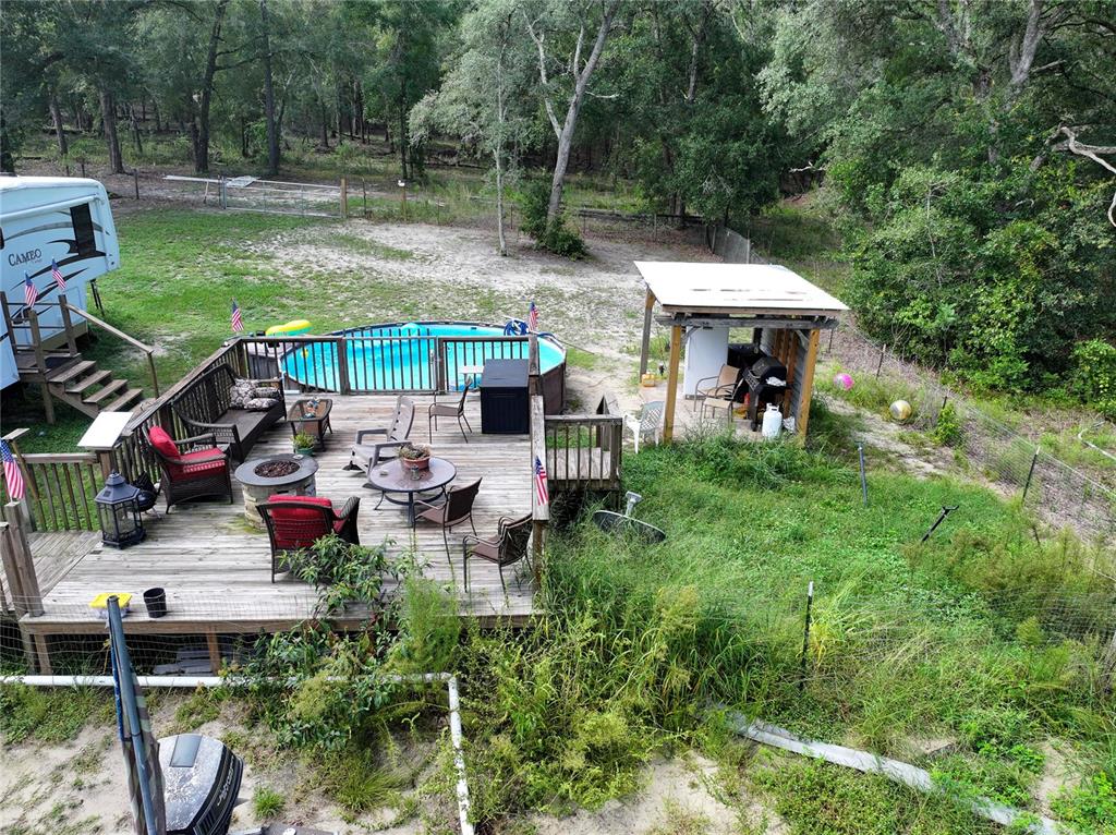 An elevated view of a wooden deck with a pool, patio furniture, and a gazebo — 1776 ANDERSON LANE, LADY LAKE, FL