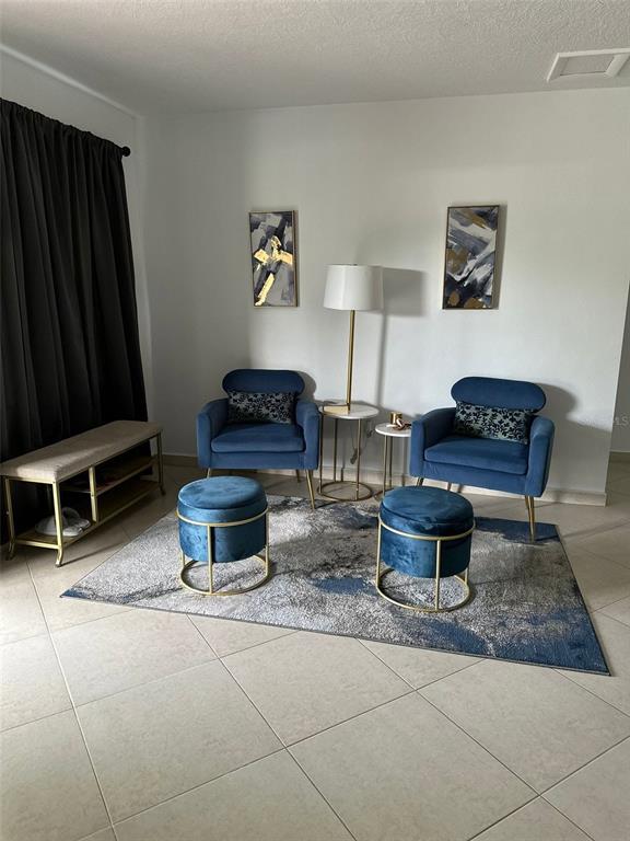 A living area features two blue velvet chairs, matching ottomans, and a floor lamp — 1211 LEHIGH STREET, KISSIMMEE, FL