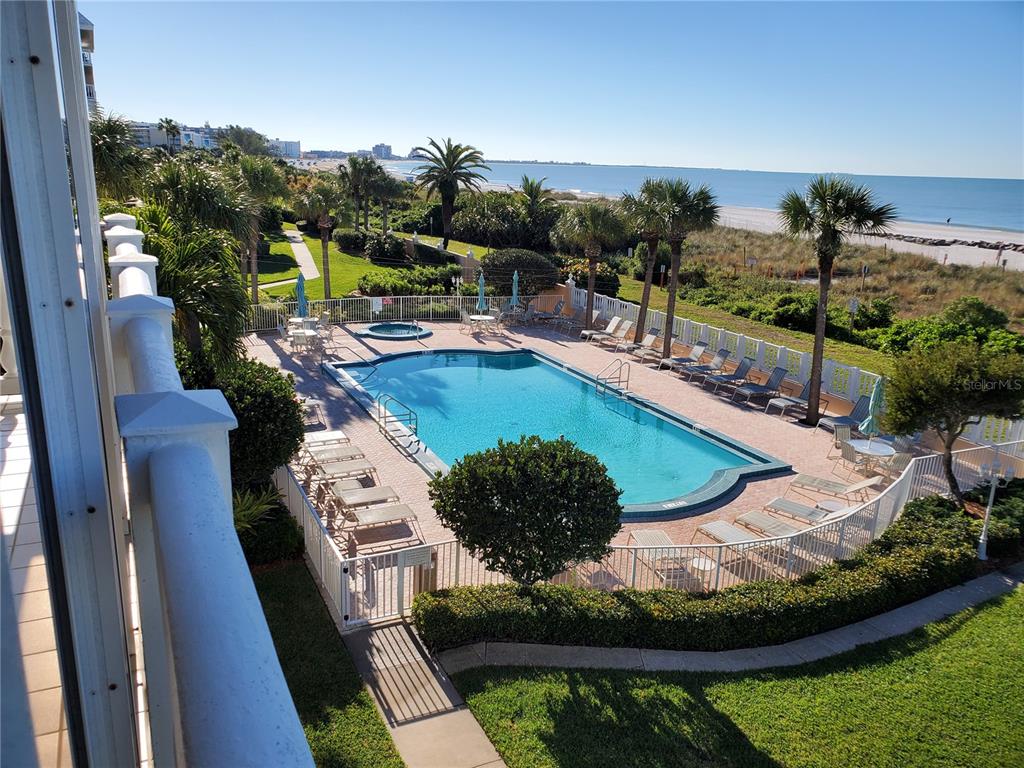 An elevated view of a swimming pool and hot tub overlooking a beach and ocean — 6650 SUNSET WAY UNIT 220, ST PETE BEACH, FL