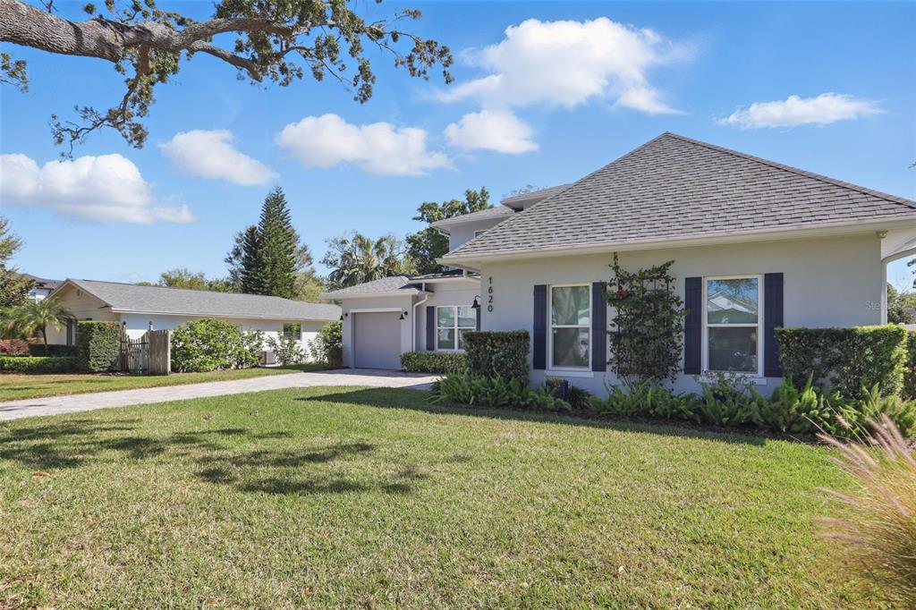 A single-story house with a gray exterior, dark shutters, and a paved driveway — 1620 PALM AVENUE, WINTER PARK, FL