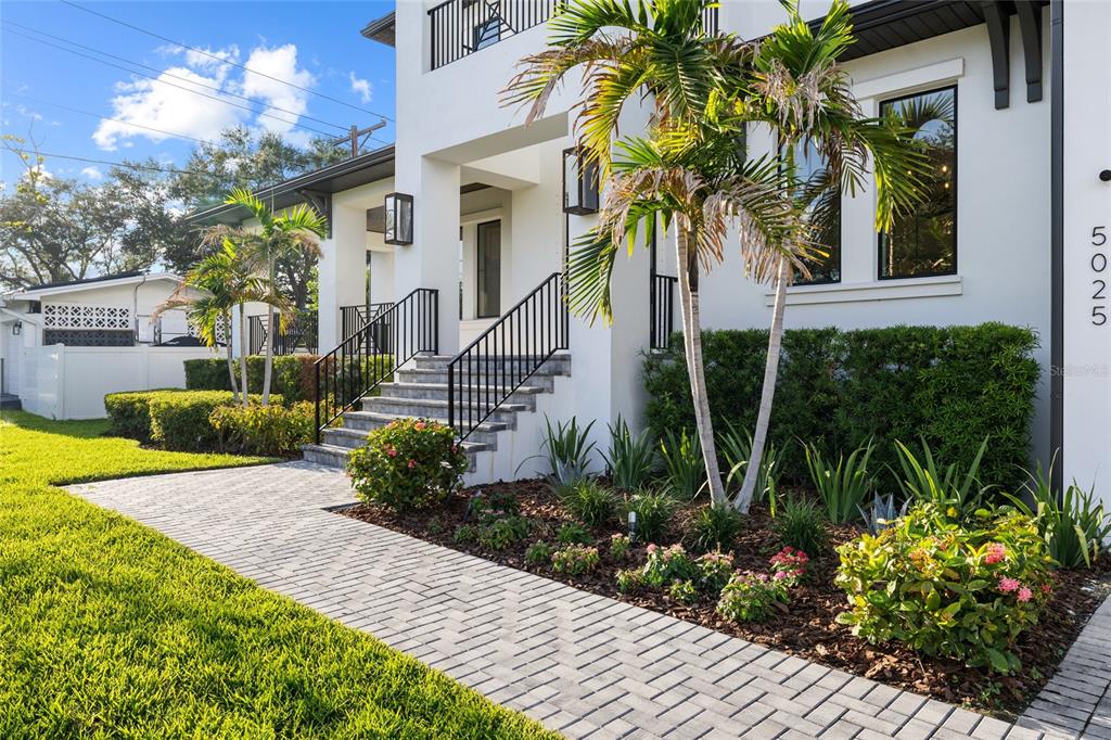 A paved walkway leads to the front entrance stairs of a modern white house — 5025 W DANTE AVENUE, TAMPA, FL