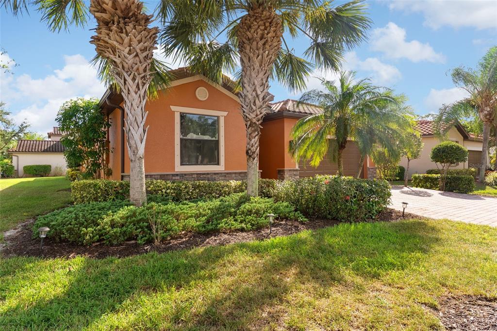 A single-story house with orange stucco walls, a tiled roof, and palm trees in front — 11068 CHERRY LAUREL DR., FORT MYERS, FL