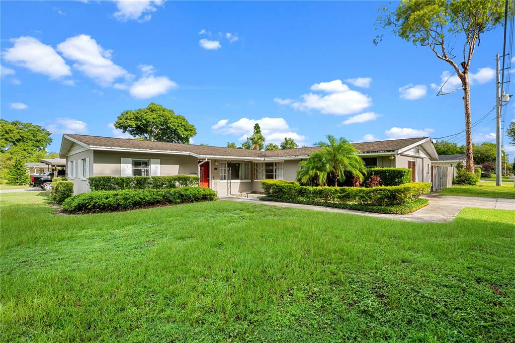 A single-story house with a light-colored exterior, a red front door, and manicured landscaping — 601 ORANOLE ROAD, MAITLAND, FL