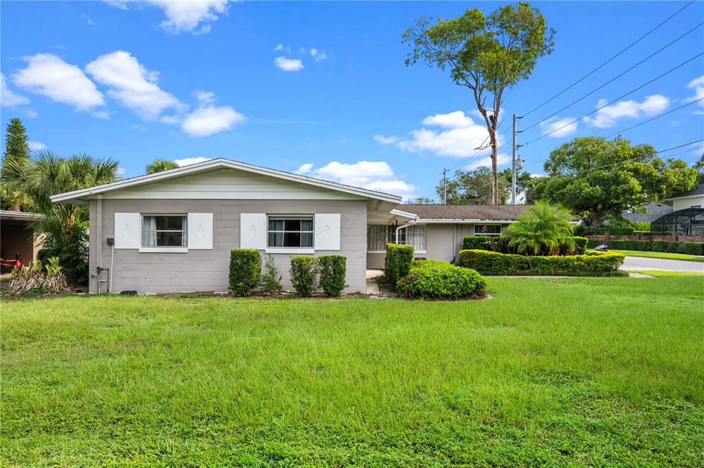 A single-story gray house with white shutters sits behind a large, green front lawn — 601 ORANOLE ROAD, MAITLAND, FL