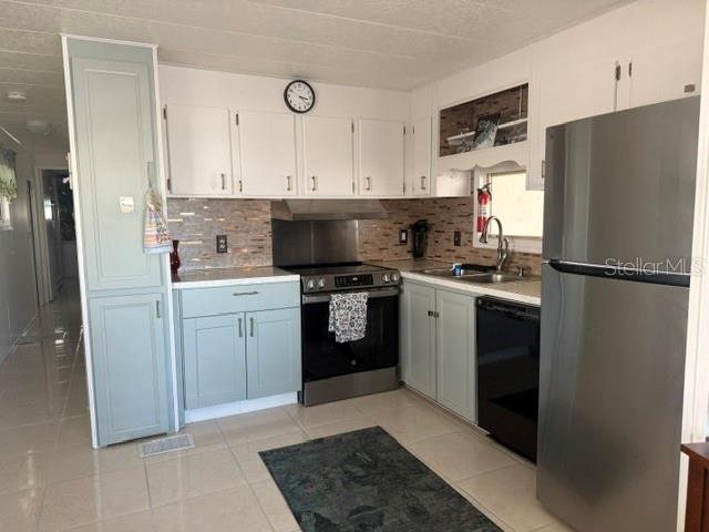 A kitchen features light blue cabinets, stainless steel appliances, and a tiled backsplash — 294 COLONIAL BOULEVARD UNIT 48, PALM HARBOR, FL