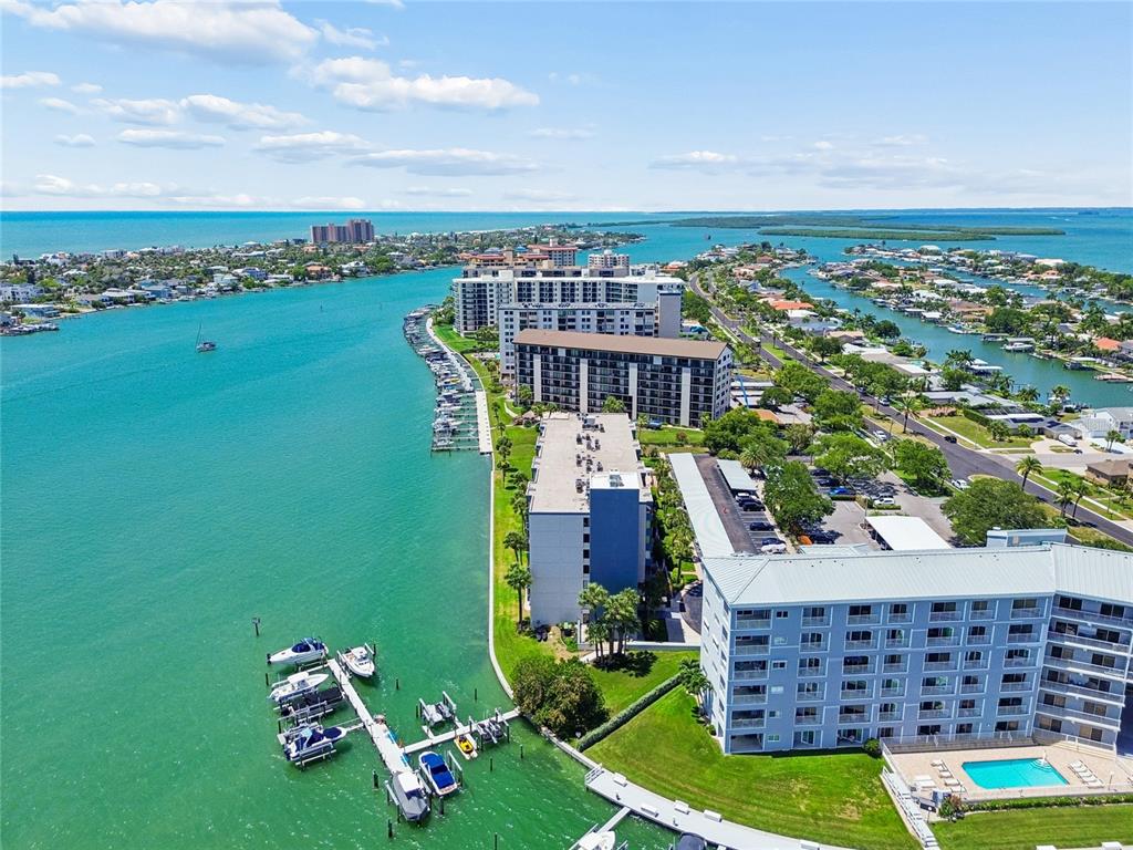 A multi-story apartment building with a covered parking lot and palm trees in front — 644 ISLAND WAY UNIT 405, CLEARWATER, FL