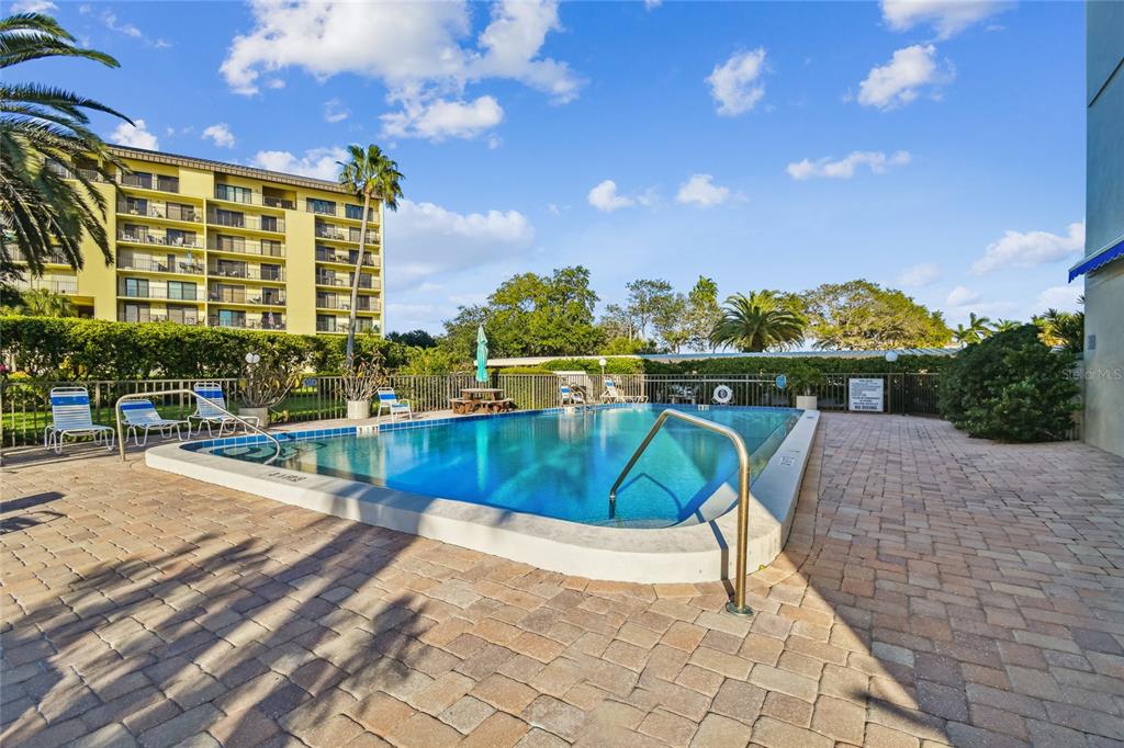 A modern open-concept living room features a large sectional sofa, kitchen island, and dark cabinetry — 644 ISLAND WAY UNIT 405, CLEARWATER, FL