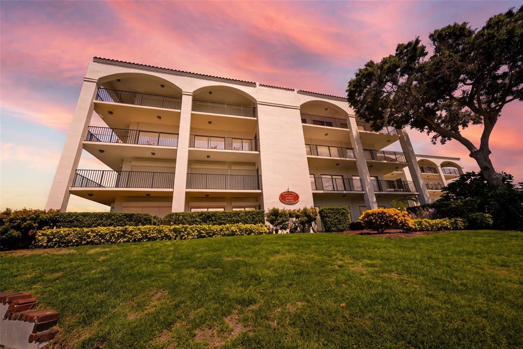 An exterior view of a multi-story apartment building with balconies overlooking the water — 301 MARINER DRIVE UNIT 301, TARPON SPRINGS, FL