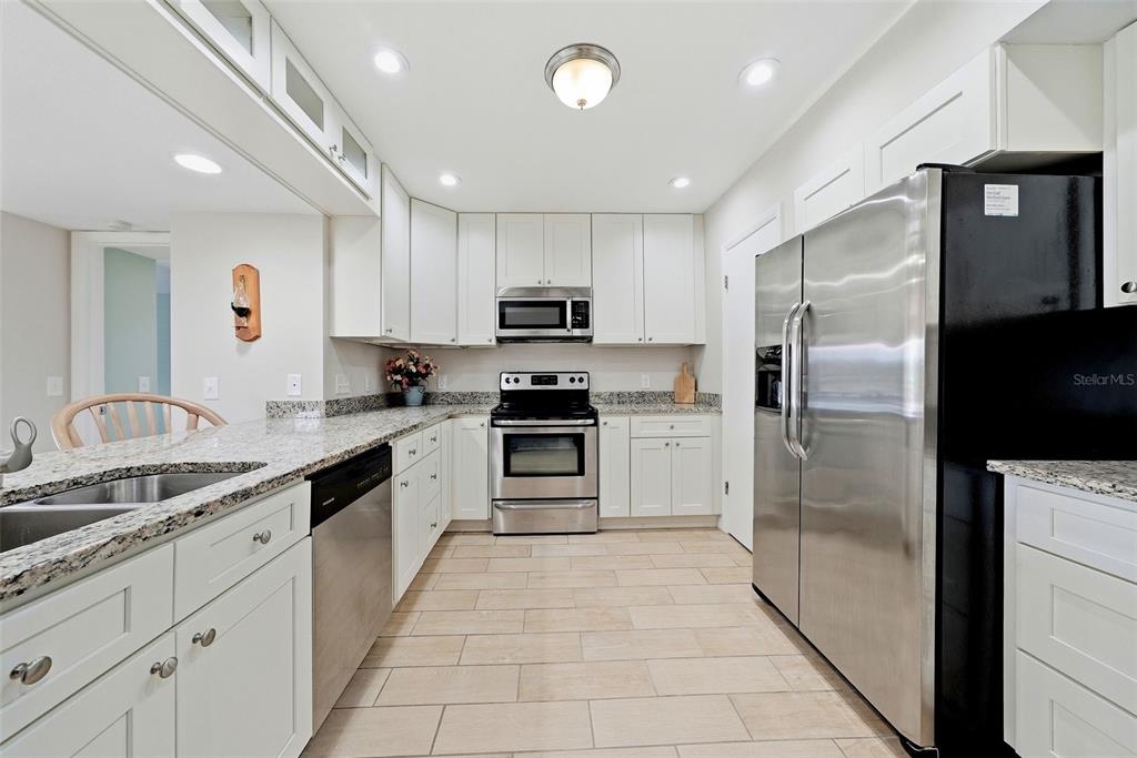 A kitchen with white cabinets, stainless steel appliances, and granite countertops — 301 MARINER DRIVE UNIT 301, TARPON SPRINGS, FL
