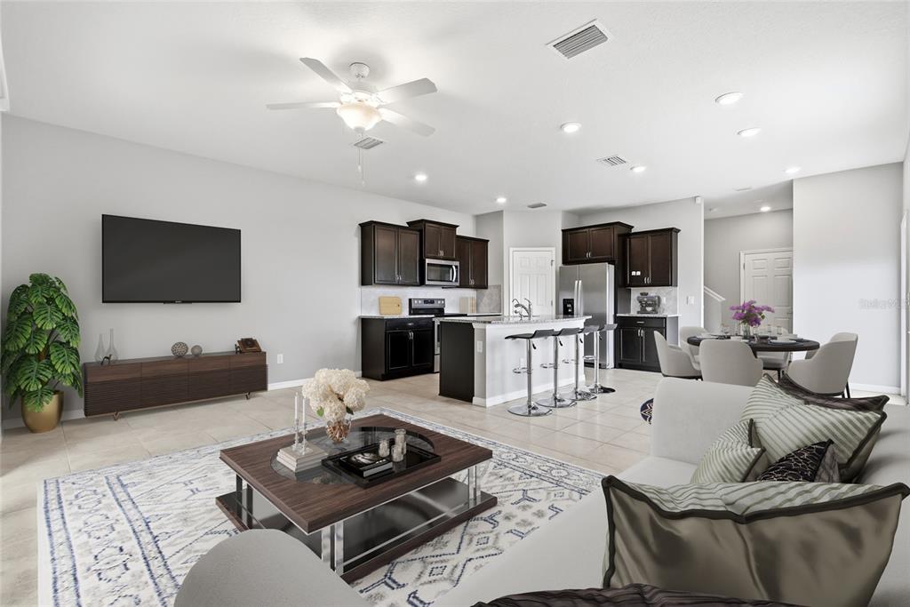 An open-concept living room and kitchen with dark cabinetry, a central island, and tile flooring — 5304 SYLVESTER LOOP, TAMPA, FL