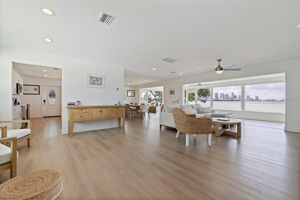 A bright, open-concept living and dining area features light wood flooring and waterfront city views — 501 22ND AVENUE SE, ST PETERSBURG, FL
