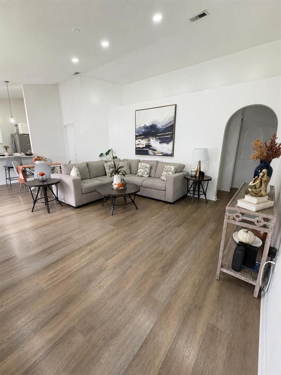A living room features a sectional sofa, wood-look flooring, and an arched doorway — 409 TALQUIN COURT, ORLANDO, FL