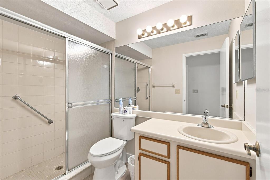 An empty room features light gray walls, wood-look flooring, a ceiling fan, and a window — 11712 SPRING TREE LANE, PORT RICHEY, FL